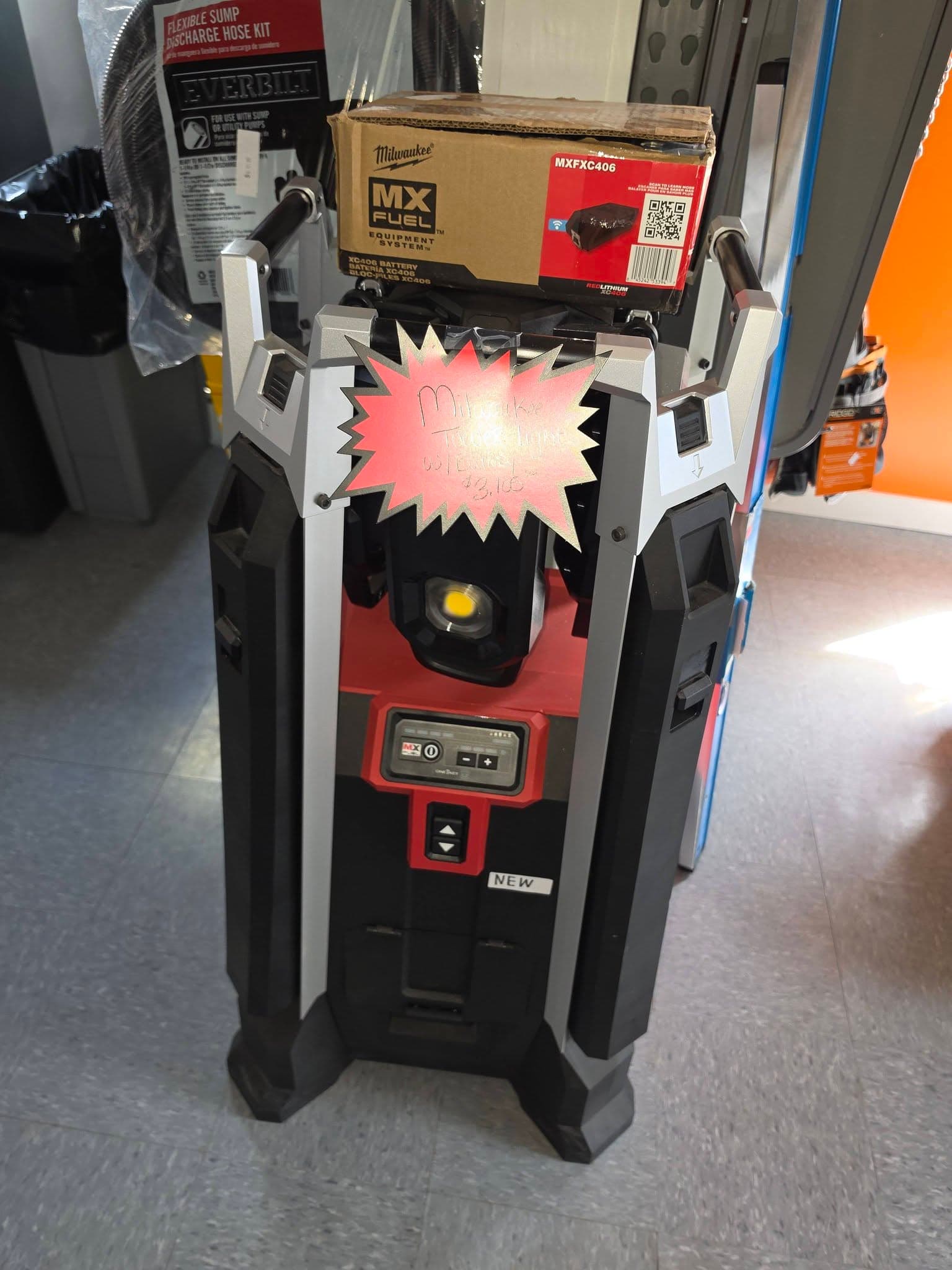 Milwaukee MX FUEL tower light with a battery box on top in a retail store.